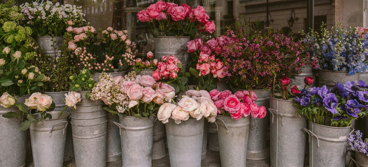 A neighborhood flower shop with buckets of bright fresh flowers on the sidewalk